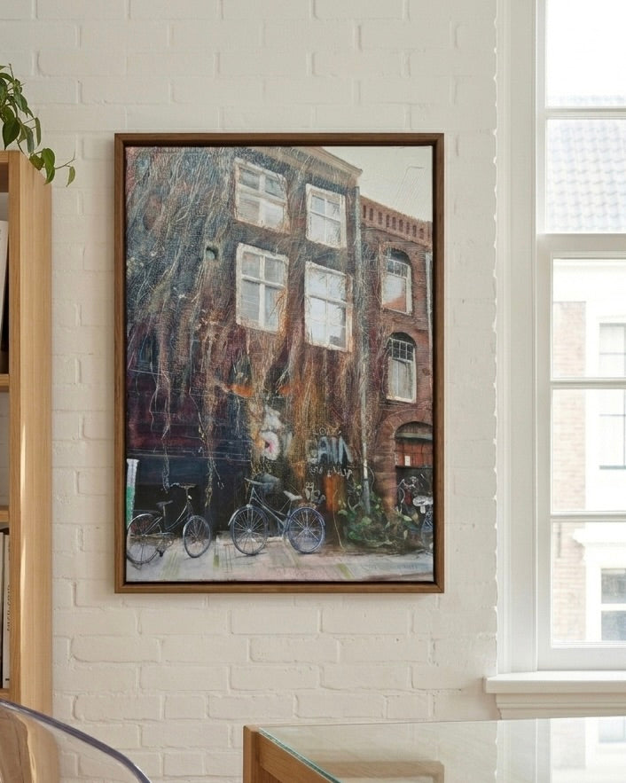 Custom commissioned painting of an Amsterdam street by Rocío Arrupe, hanging on a white brick wall